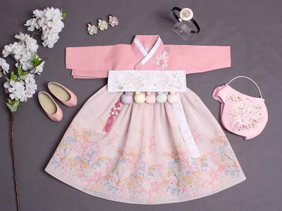 Spring baby girl hanbok that comes with a dress in a floral spring themed design. The hanbok accessories included in the complete set is also shown in the picture which includes dol shoes, a brooch, jobawi (hanbok hat), and a headband.