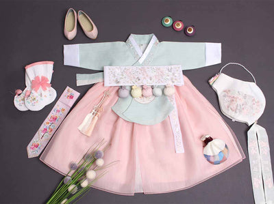 This hanbok for baby girls includes a teal jeogori and light pink dress. The jeogori has a floral embroidery for a beautiful look.