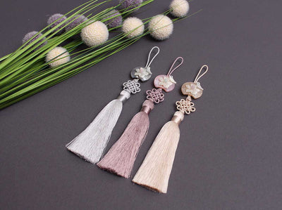 The Ornament Floral Birdie Tassel Norigae is a fun accessory to wear for both formal and informal occasions.  It's available in buff, coral, and gray.