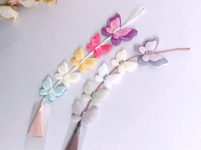 The 5x Butterfly Tassel Norigae is an ideal addition to any hanbok and comes in two color combinations. The purple tassel or the salmon tassel each of which comes with five butterflies.