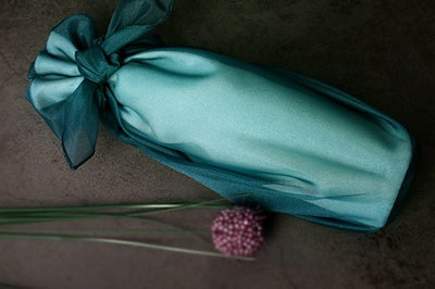 Dark aqua lucid Korean Bojagi makes wrapping gifts with an oblong shape very simple, and tying a bow using the fabric wrapping paper is just the cherry on top.