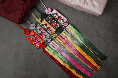 If you're looking for a decoration for hanbok or Bojagi, you should choose the Floral Patched Butterfly Trio Tassel Norigae. Here are the 12 colors all lined up together that we offer.